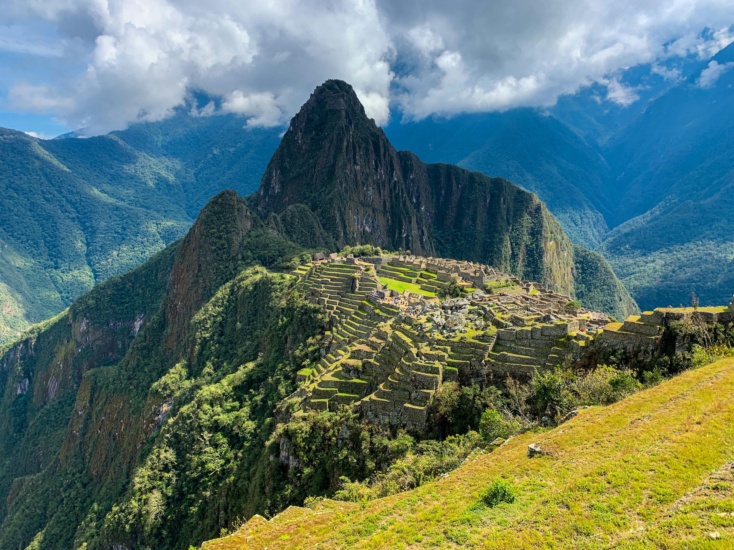 A breathtaking view of Machu Picchu in Peru surrounded by lush mountains and clouds.